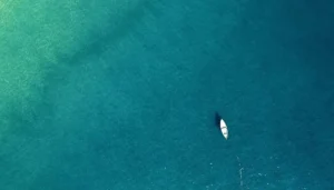 Embarcación solitaria navegando en mar abierto bajo el cielo despejado