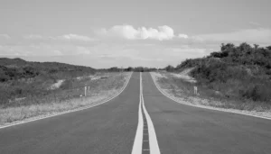 Vista en blanco y negro de una carretera que se extiende hacia el horizonte