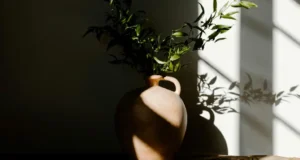 Jarrón de cerámica con plantas verdes, usado como elemento decorativo interior