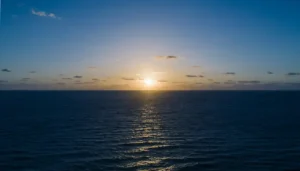 Mar tranquilo iluminado por el sol alto en un cielo despejado