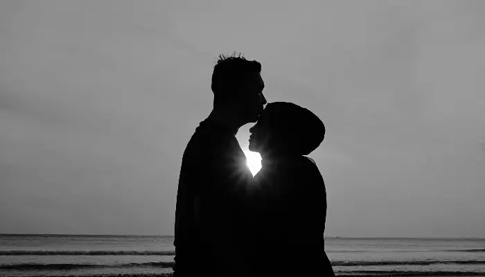 Pareja en silueta, frente a frente, con fuerte contraste de luz en blanco y negro