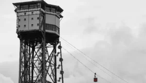 eleférico capturado en blanco y negro, destacando su estructura y el entorno